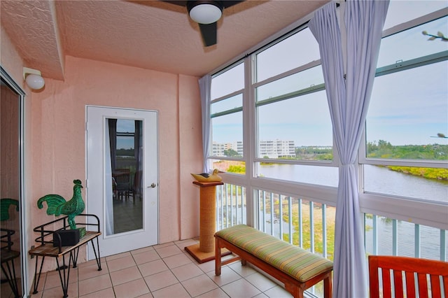 sunroom with a water view and ceiling fan