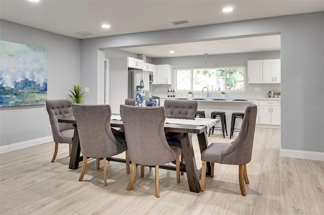 dining area featuring sink and light hardwood / wood-style floors