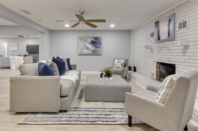 living room with light hardwood / wood-style flooring and a brick fireplace