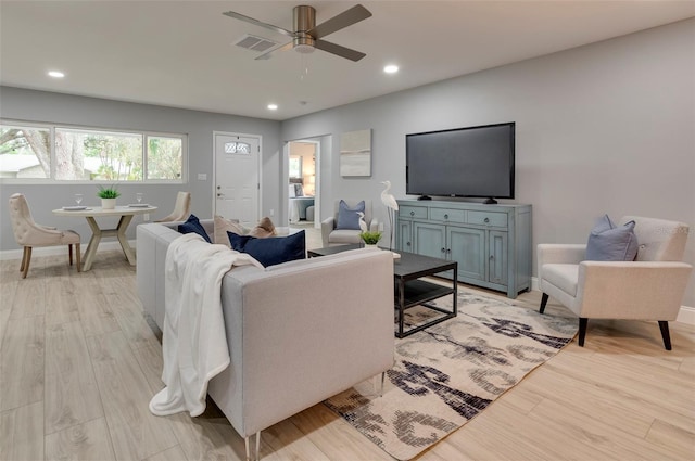 living room featuring light hardwood / wood-style floors and ceiling fan