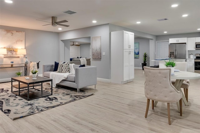 living room with ceiling fan and light hardwood / wood-style floors