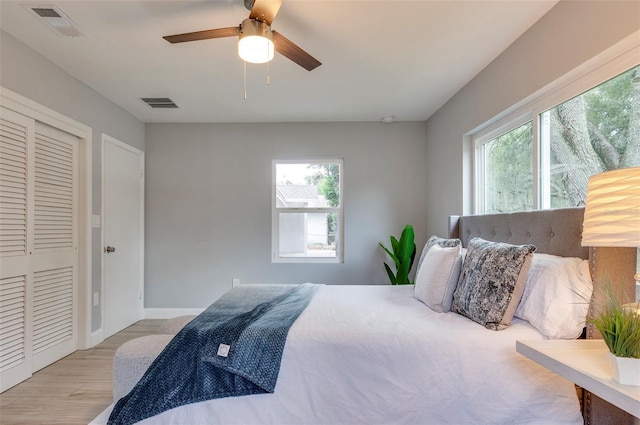 bedroom with light wood-type flooring, a closet, and ceiling fan