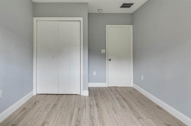 unfurnished bedroom with light hardwood / wood-style floors and a closet