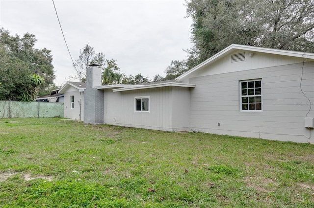 rear view of property featuring a lawn