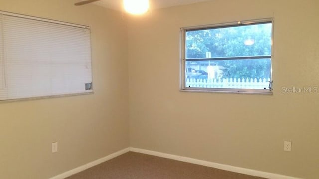 carpeted spare room featuring ceiling fan