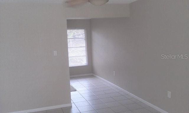 spare room featuring light tile patterned floors and ceiling fan