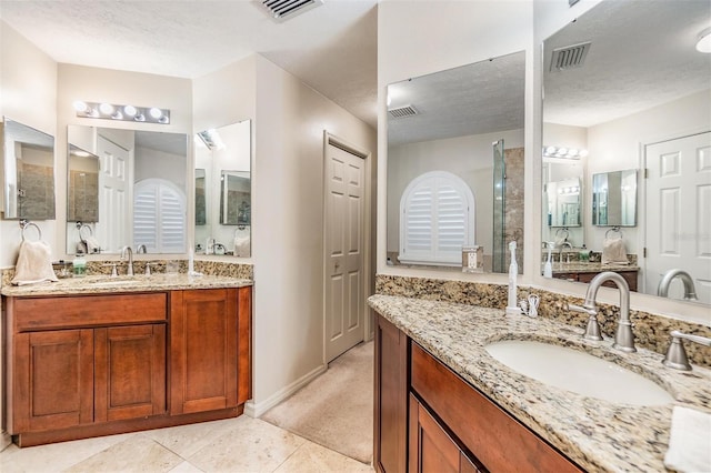 bathroom featuring tile patterned flooring, vanity, and a textured ceiling