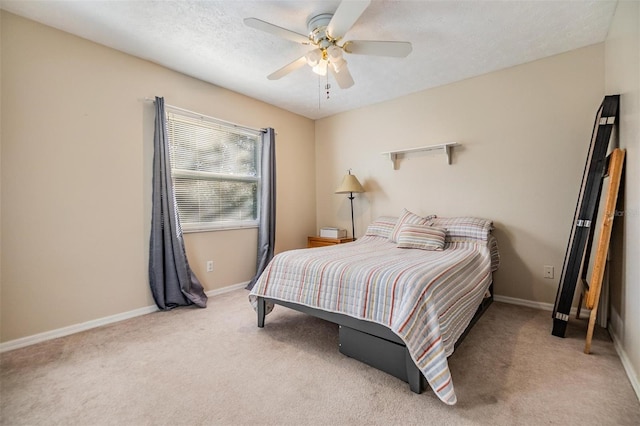 bedroom featuring ceiling fan, light colored carpet, and a textured ceiling