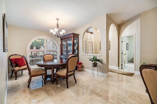 dining area with a textured ceiling and a chandelier