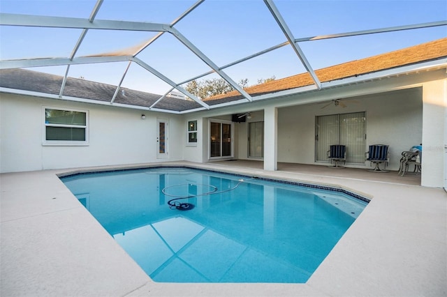 view of swimming pool featuring ceiling fan, a patio area, and glass enclosure