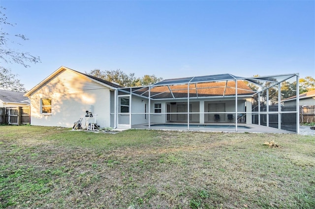 back of house with a yard, a patio area, and a lanai