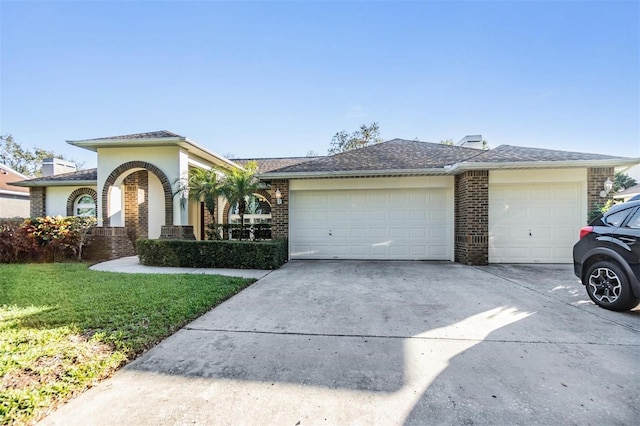 view of front of property featuring a garage and a front lawn