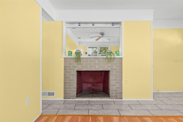 details featuring a brick fireplace, hardwood / wood-style flooring, and ceiling fan