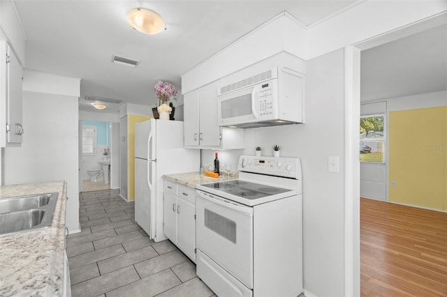 kitchen featuring sink, white appliances, light hardwood / wood-style flooring, and white cabinets