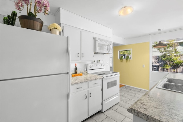 kitchen with pendant lighting, light tile patterned floors, white appliances, and white cabinets