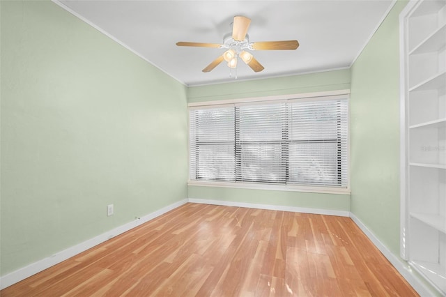 spare room featuring hardwood / wood-style flooring, ceiling fan, and crown molding