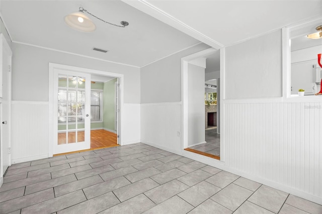 spare room featuring light tile patterned floors, ornamental molding, and ceiling fan