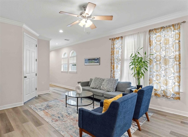 living room featuring light wood-type flooring, plenty of natural light, ornamental molding, and ceiling fan