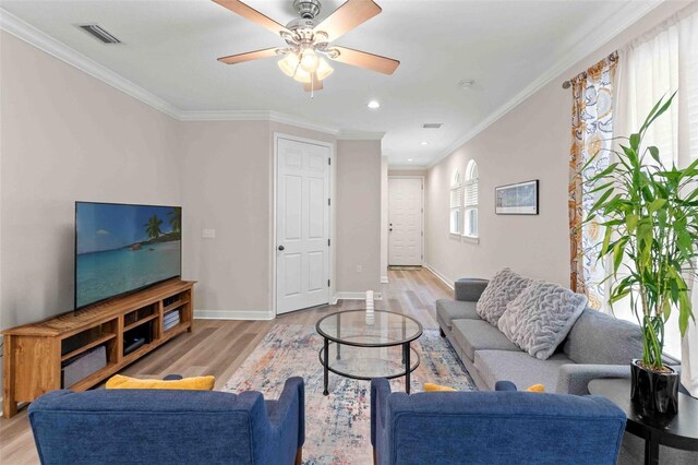 living room with light hardwood / wood-style flooring, ceiling fan, and crown molding