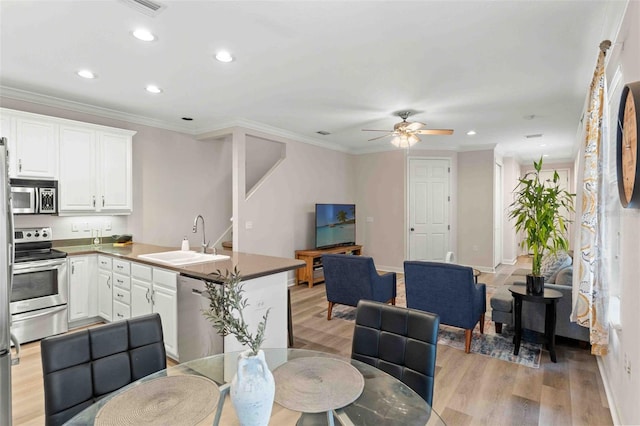 kitchen with white cabinetry, sink, crown molding, and appliances with stainless steel finishes