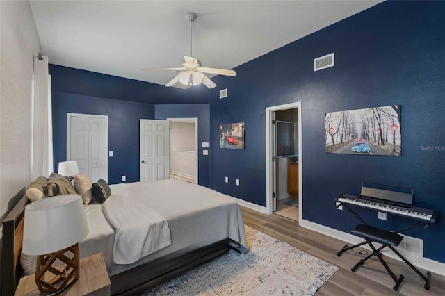 bedroom with ensuite bath, ceiling fan, and hardwood / wood-style floors