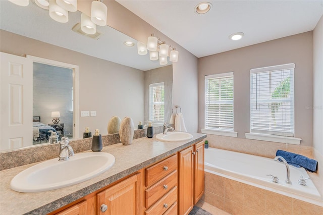 bathroom featuring vanity and a relaxing tiled tub