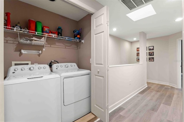 clothes washing area featuring light hardwood / wood-style floors and separate washer and dryer