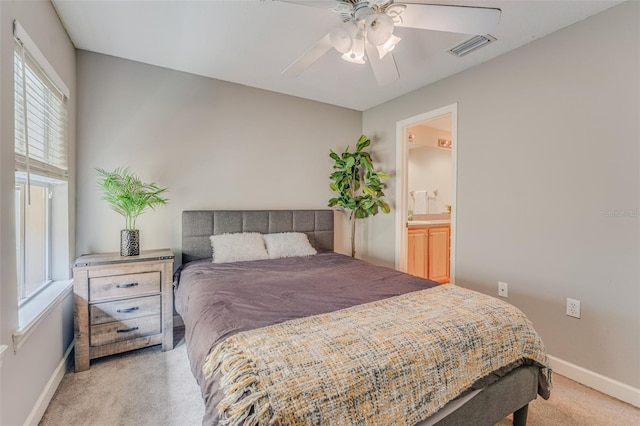 carpeted bedroom with ensuite bath and ceiling fan