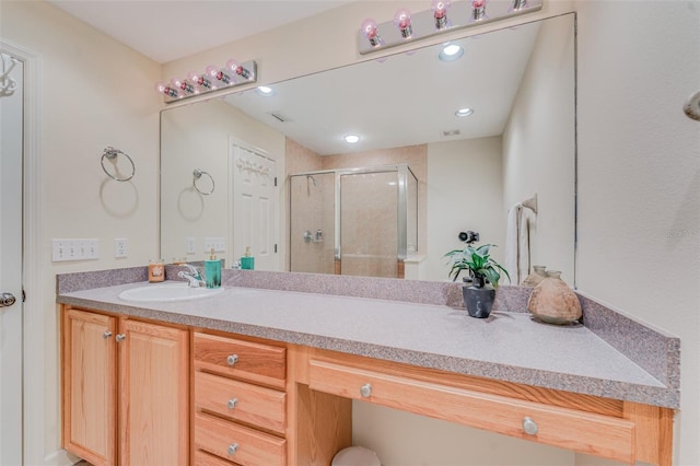 bathroom with vanity and a shower with shower door