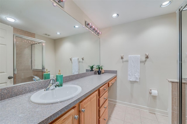 bathroom with tile patterned flooring, vanity, and walk in shower