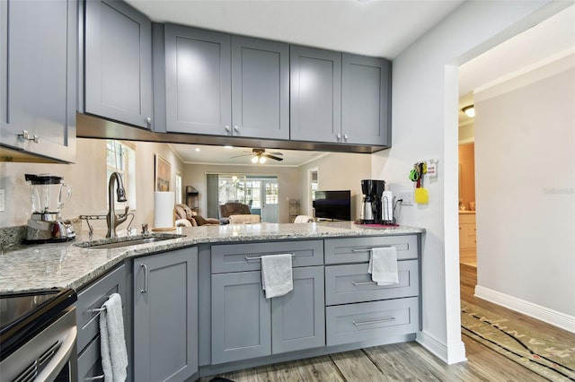 kitchen with gray cabinets, ceiling fan, sink, and light hardwood / wood-style floors