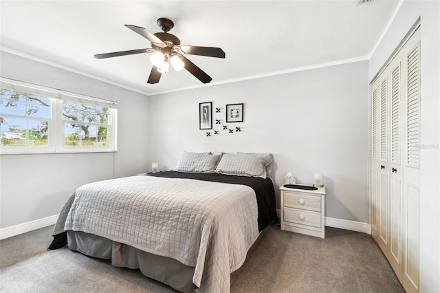 carpeted bedroom with a closet, ceiling fan, and crown molding