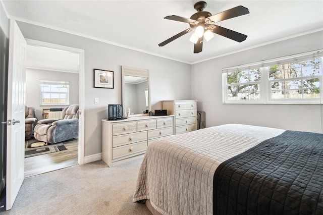 carpeted bedroom with ceiling fan and ornamental molding