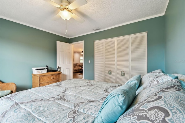 bedroom featuring a textured ceiling, ceiling fan, crown molding, and a closet