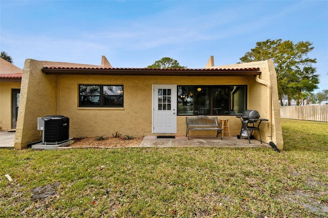 rear view of property featuring central AC and a yard