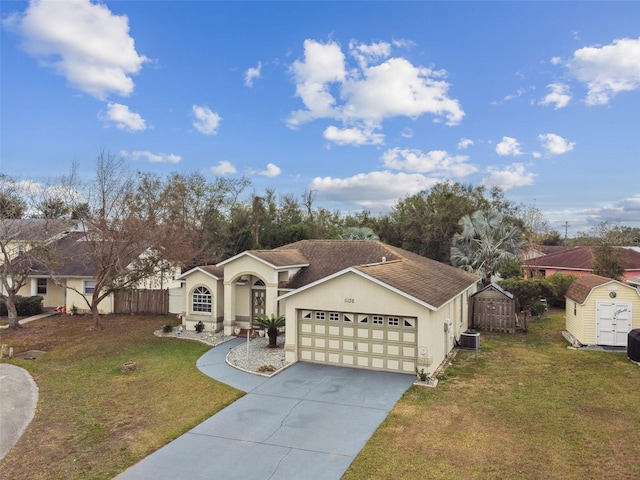 view of front of home with central AC unit, a garage, a storage shed, and a front lawn