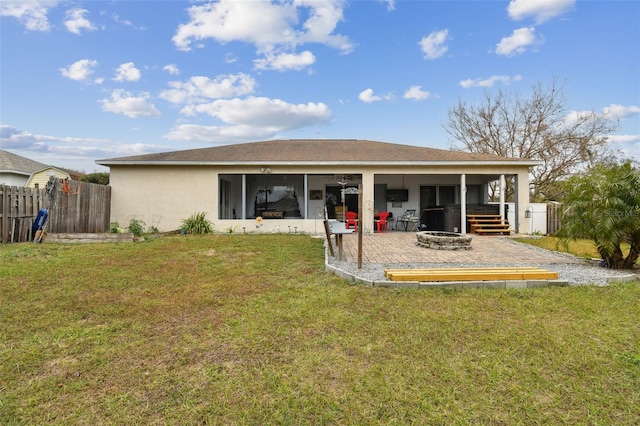 back of property with a lawn, a patio, and a fire pit