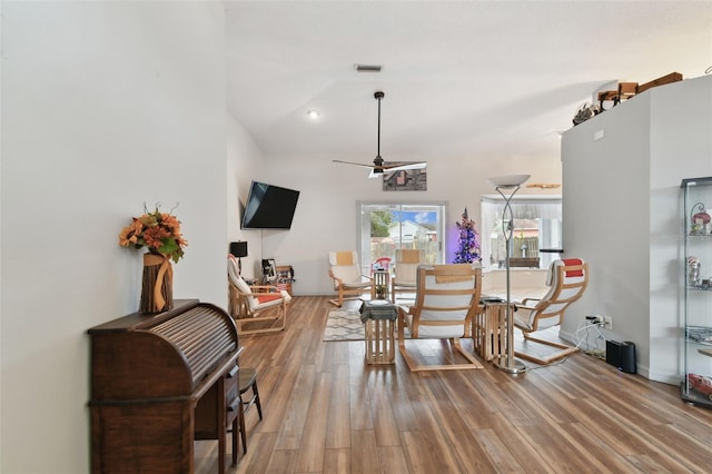 living area with wood-type flooring and ceiling fan