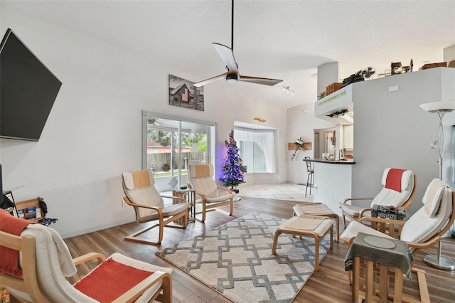 living room with ceiling fan, light hardwood / wood-style flooring, and a high ceiling