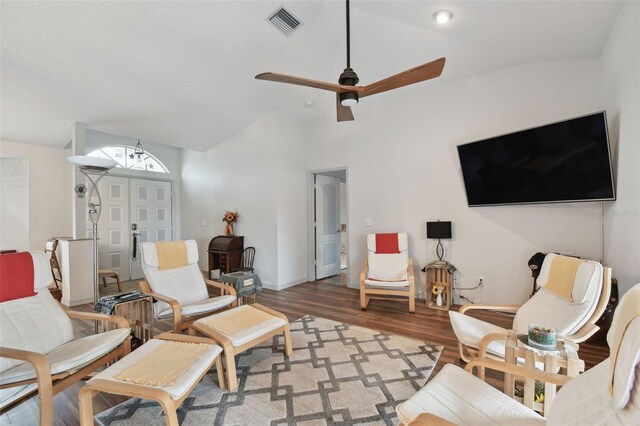 living area with ceiling fan, wood-type flooring, and lofted ceiling