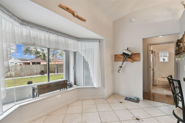 interior space featuring light tile patterned floors and vaulted ceiling