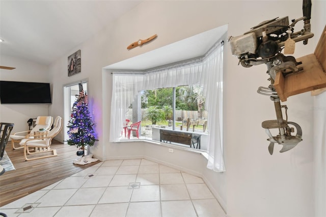 interior space with light tile patterned floors and vaulted ceiling