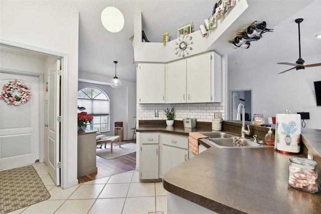 kitchen with white cabinetry, sink, tasteful backsplash, pendant lighting, and light tile patterned floors