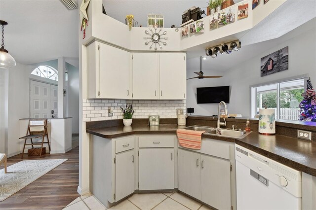 kitchen with decorative backsplash, white dishwasher, ceiling fan, sink, and white cabinets