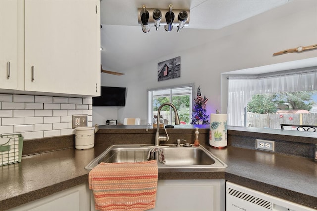 kitchen featuring white cabinets, backsplash, sink, and dishwashing machine