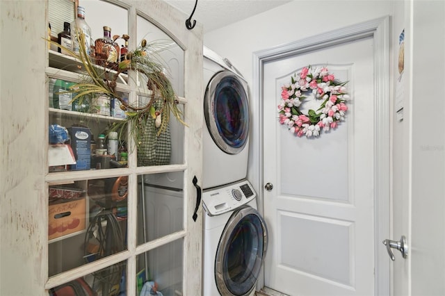 laundry room featuring stacked washing maching and dryer and a textured ceiling