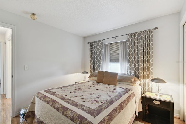 bedroom with wood-type flooring and a textured ceiling