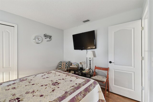 bedroom featuring hardwood / wood-style flooring and a textured ceiling