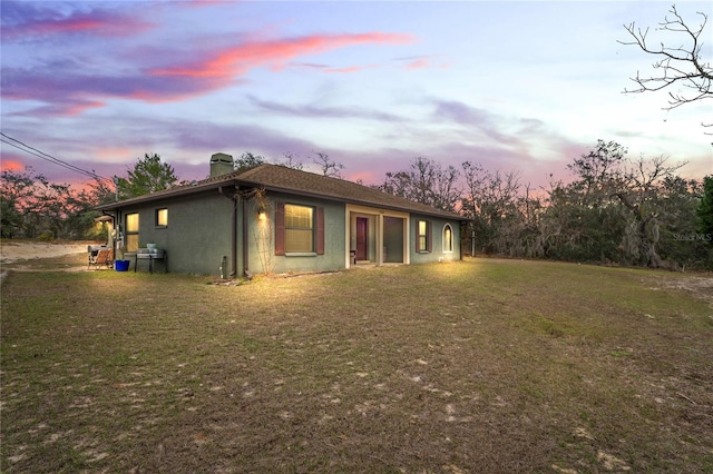 back house at dusk with a yard