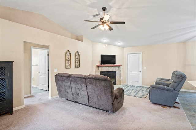 carpeted living room with ceiling fan, a tile fireplace, and vaulted ceiling